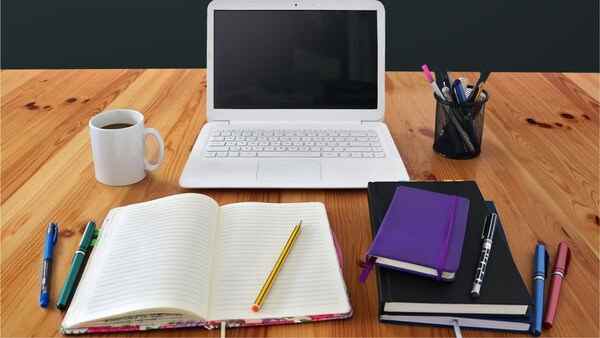 A calm workspace with a laptop and notebook on a table